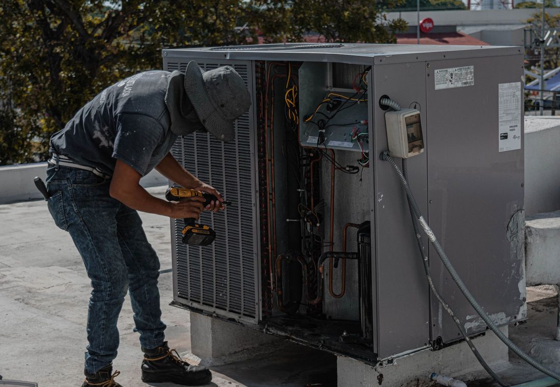 HVAC technician servicing an air conditioning unit